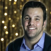 Smiling man with dark hair and scruffy facial hair